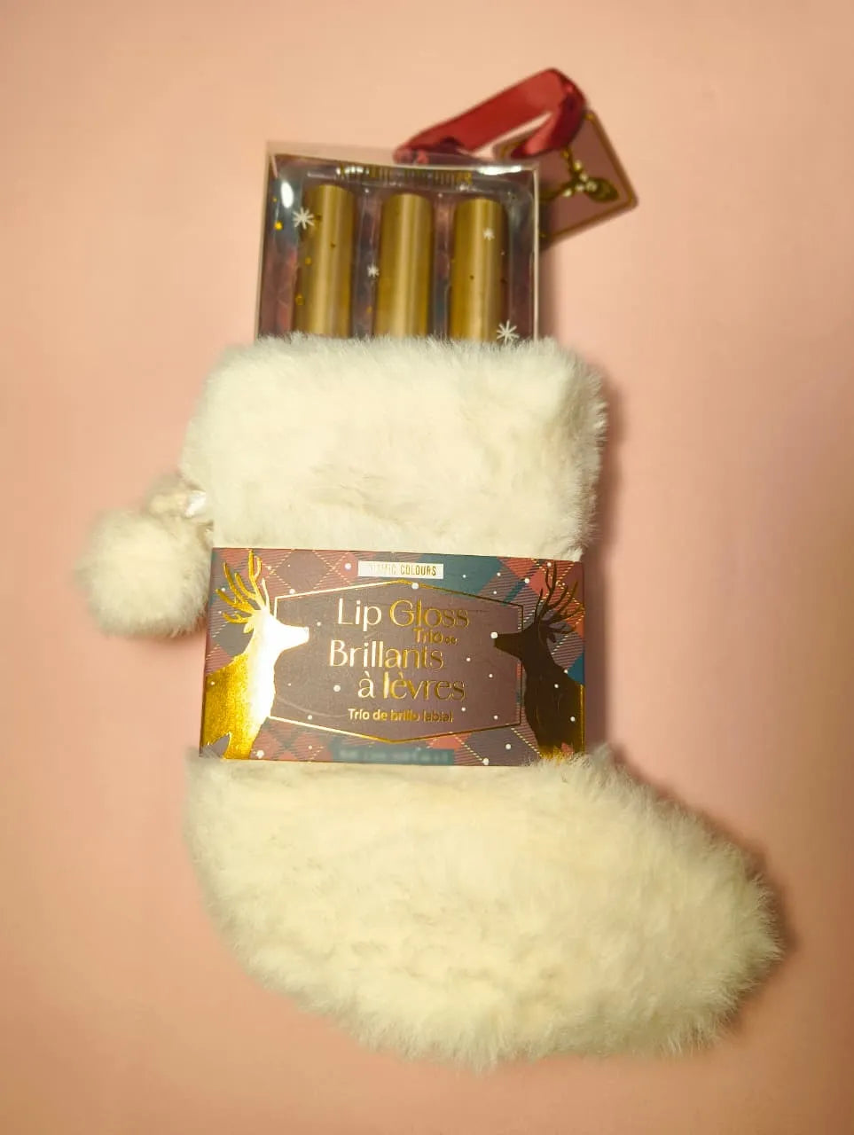 Beauty Concepts Stockings Lip Gloss in a festive white stocking on a pastel pink background.