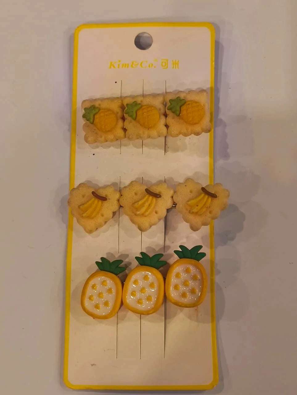 Set of fruit-themed earrings on a display card with 'Kim & Co' branding.