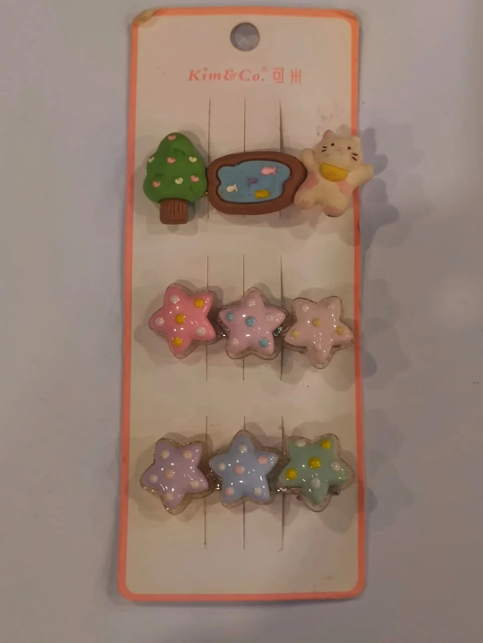 Set of colorful star-shaped hair clips on a 'Kim & Co' branded card.