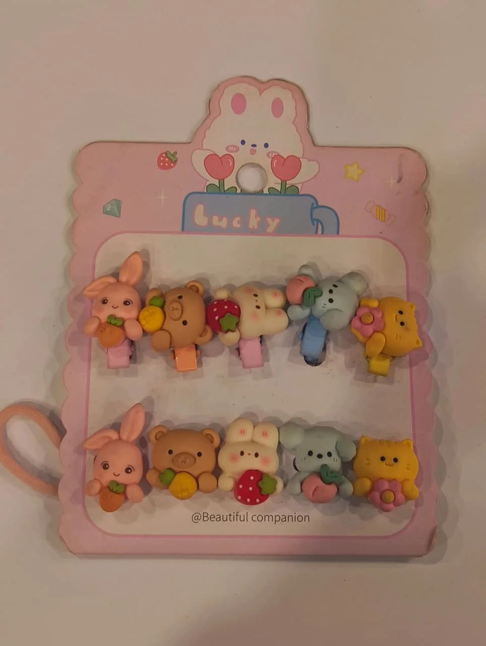 Set of colorful animal-shaped hair clips on a pink display card with 'Bucky' branding.
