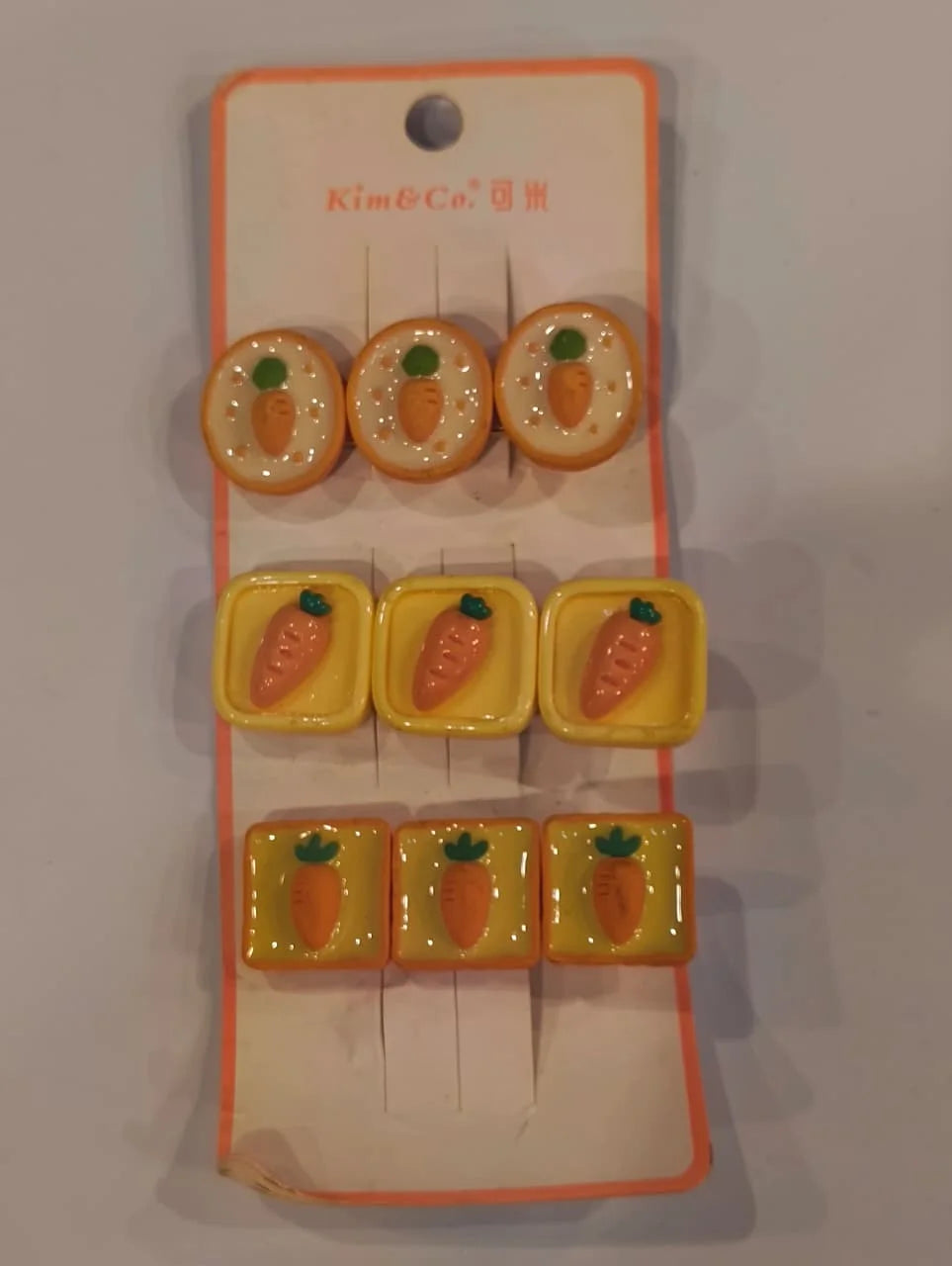Set of carrot-shaped rubber stamps on a card with 'Kim & Co.' branding.