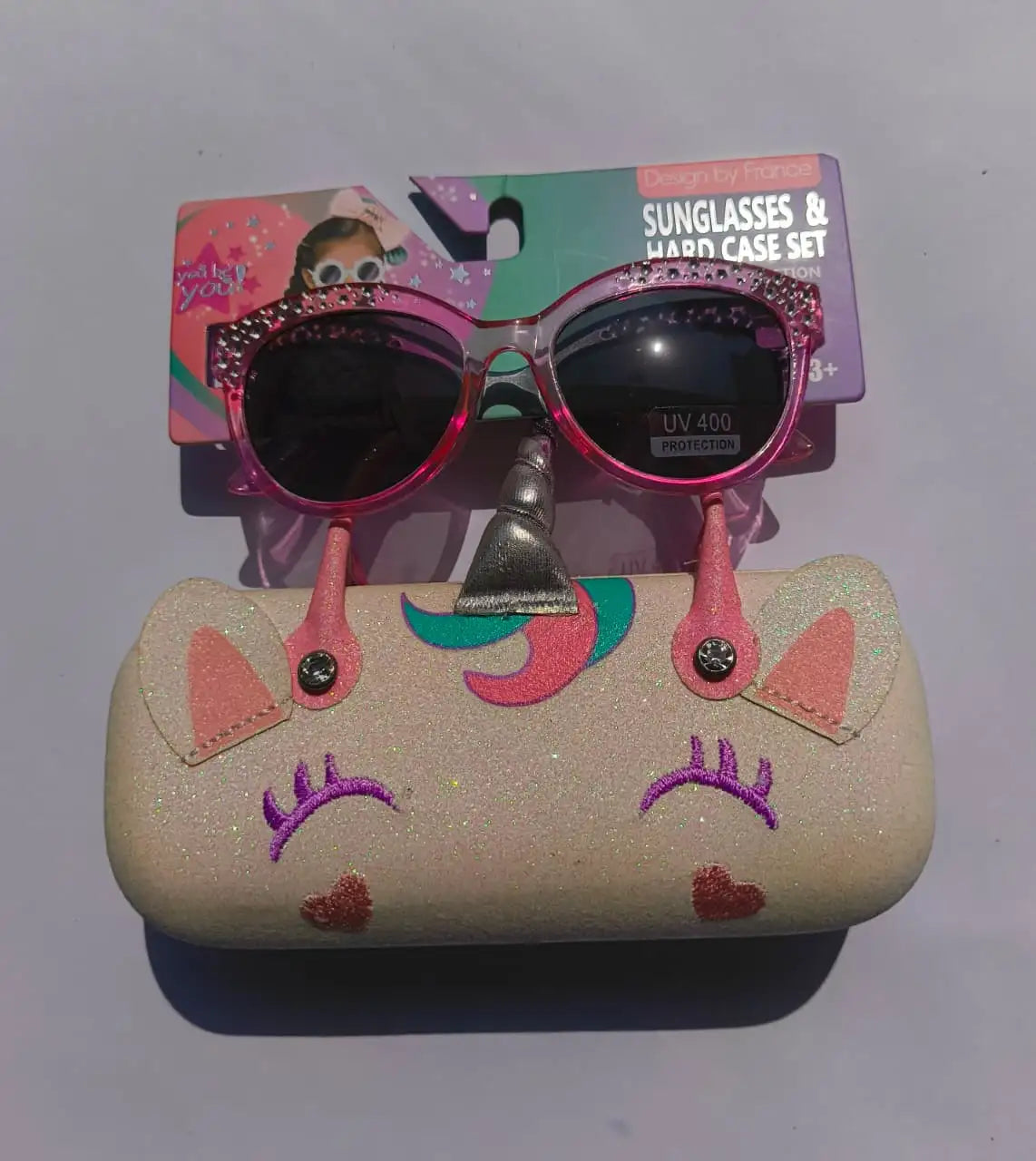 Pink sunglasses with decorative case on a white background