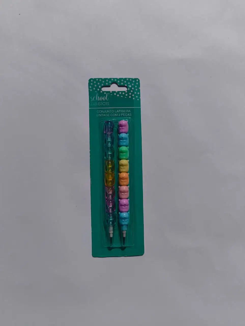 Set of colorful pencils in packaging on a gray background
