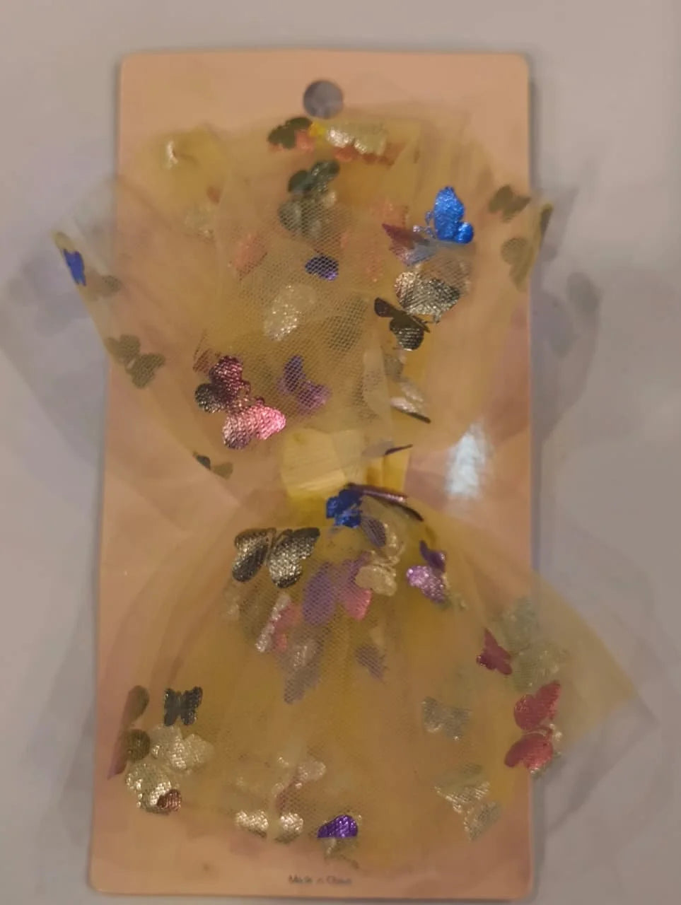 Packaged colorful butterfly decorations on a beige card.